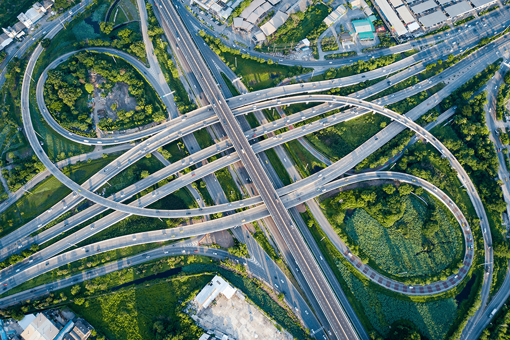 An aerial view of a complex highway system surrounded by greenery